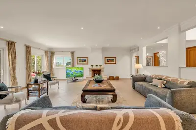 a living room with couches and a tv at Extraordinary Villa on an elevated position in Quinta do Lago in Quinta do Lago