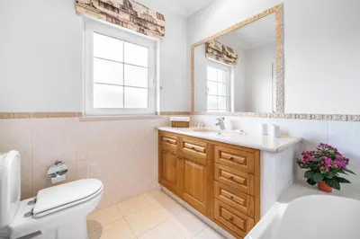 a bathroom with a sink and a toilet and a mirror at Extraordinary Villa on an elevated position in Quinta do Lago in Quinta do Lago