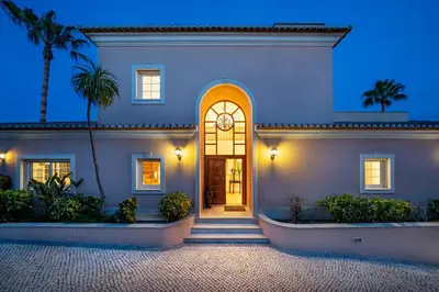 a house with a front door at night at Extraordinary Villa on an elevated position in Quinta do Lago in Quinta do Lago