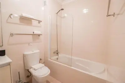 a bathroom with a toilet and a glass shower at Old Village Vilamoura in Quarteira