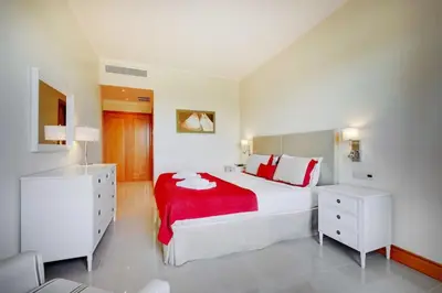 a dining room with a table and chairs and a living room at The Prime @ The Residences Vilamoura in Quarteira