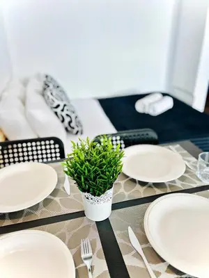 a table with white plates and a potted plant on it at Flat Luxuous Praia da Oura in Albufeira