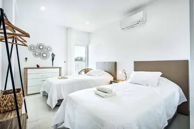 a bedroom with two beds with white sheets at Villa Aventura in Albufeira