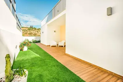 an internal courtyard of a house with green grass at Villa Aventura in Albufeira
