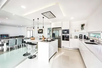 a kitchen with white cabinets and a kitchen island at Villa Aventura in Albufeira