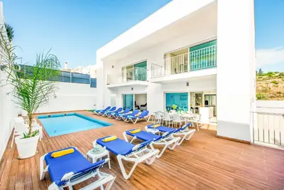 a villa with a swimming pool and lounge chairs at Villa Aventura in Albufeira