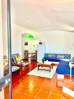 a living room with a blue couch and a table at Resort Albufeira T1, Praia da Oura in Albufeira