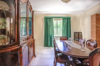 a dining room with a table and green curtains at Villa Vivienda Rosa in Albufeira