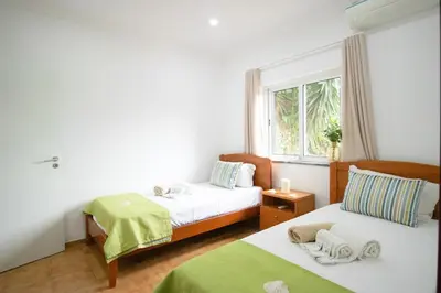 a bedroom with two beds and a window at Villa dos Sonhos - Wide Dreams in Albufeira