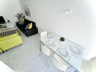 a living room with a white table and chairs at Apartamento 5 Estrelas Praia da Oura in Albufeira