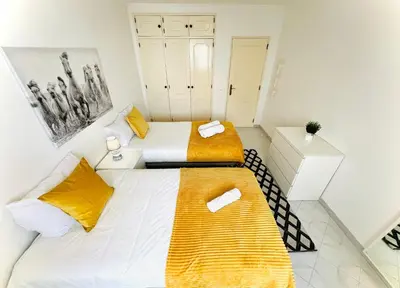 two beds in a room with yellow and white at Apartamento 5 Estrelas Praia da Oura in Albufeira