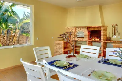 a dining room with a table and a fireplace at Villa Lisianto in Albufeira
