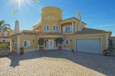 a large yellow house with a large garage at Villa Lisianto in Albufeira