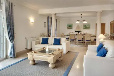 a living room with white furniture and blue pillows at Villa Lisianto in Albufeira