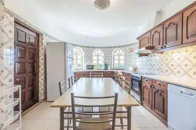 a kitchen with wooden cabinets and a table and chairs at Villa Natalia Sun in Albufeira