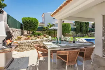 a patio with a table and chairs and a fireplace at Villa Tilia in Galé