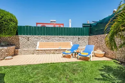 two blue chairs sitting on a patio next to a stone wall at Villa Tilia in Galé