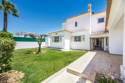 a white house with a palm tree in the yard at Villa Tilia in Galé