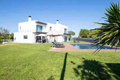 a large white house with a pool in front of it at Villa Dala in Albufeira