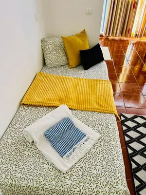 a bed with a blanket and pillows on it at Resort Albufeira T1, Praia da Oura in Albufeira