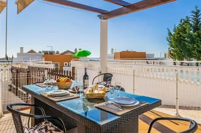 a table and chairs on a balcony with a view at Casa Oliveira in Albufeira