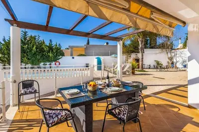 a patio with a table and chairs on a deck at Casa Oliveira in Albufeira