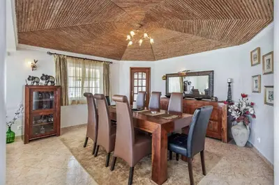 a dining room with a table and chairs and a mirror at Casa Oliveira in Albufeira