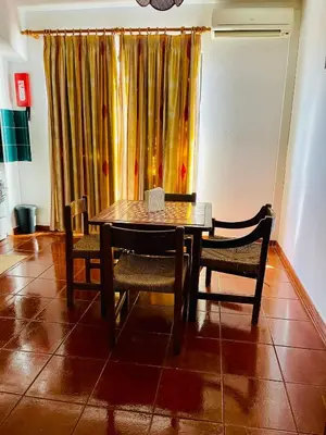 a table and chairs in a room with a curtain at Resort Albufeira T1, Praia da Oura in Albufeira