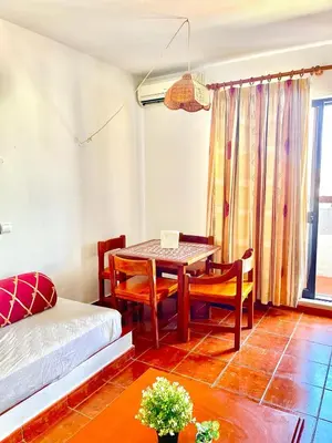 a living room with a table and chairs and a bed at Resort Albufeira T1, Praia da Oura in Albufeira