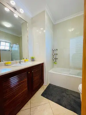 a bathroom with a sink and a tub and a mirror at Invited to Albufeira in Guia