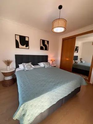 a bedroom with a large bed with a blue comforter at Invited to Albufeira in Guia