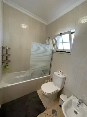 a bathroom with a toilet and a tub and a sink at Invited to Albufeira in Guia