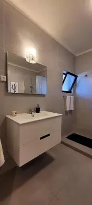 a bathroom with a white sink and a mirror at Jardins da Falesia in Albufeira