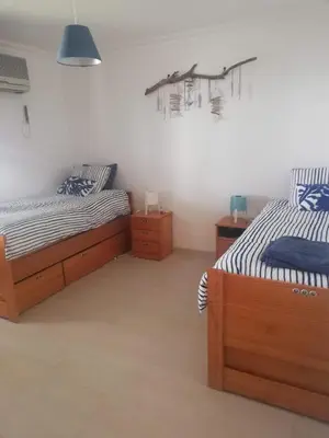 a bedroom with two twin beds and a painting on the wall at Jardins da Falesia in Albufeira