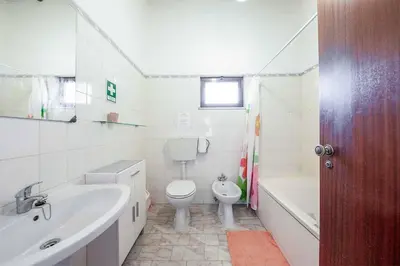 a bathroom with a sink and a toilet and a bath tub at Casa Nomanico in Estói