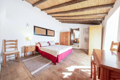 a bedroom with a bed and a wooden ceiling at Casa Nomanico in Estói