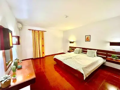 a bedroom with a large bed and wooden floors at Resort Albufeira T1, Praia da Oura in Albufeira