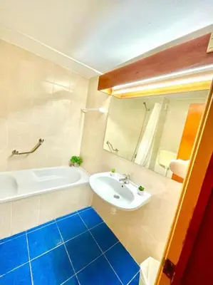 a bathroom with a white tub and a sink and a bath tub at Resort Albufeira T1, Praia da Oura in Albufeira