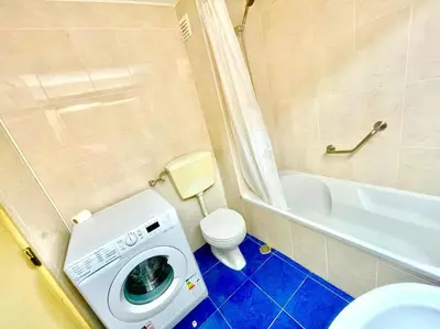 a bathroom with a washing machine and a toilet at Resort Albufeira T1, Praia da Oura in Albufeira