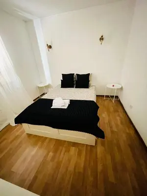 a bedroom with a bed with black sheets and a wooden floor at Apartament Two bedrooms Praia de Quarteira in Vilamoura