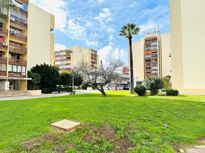 a park with a palm tree and some buildings at Apartament Two bedrooms Praia de Quarteira in Vilamoura