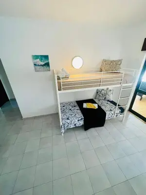 a room with two bunk beds and a tile floor at Amazing Studio Flat Albufeira in Albufeira
