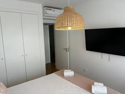 a room with a bed with a lamp and a flat screen tv at The Albufeira Concierge - Prime Sunset Design in Albufeira