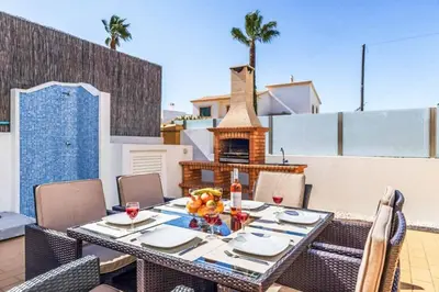 a dining table on a balcony with a fireplace at Villa Astro in Albufeira