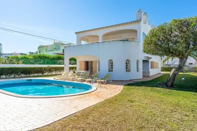 a villa with a swimming pool in front of a house at Villa Noras in Albufeira