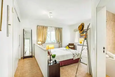 a bedroom with a large bed and two lamps on tables at Villa Sunset Golf in Vilamoura