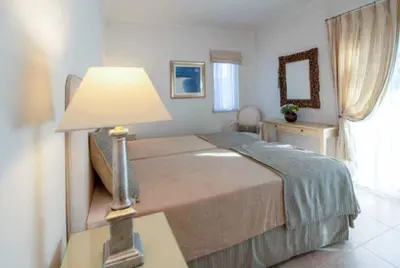 a bedroom with a bed and a dresser and windows at Villa Sunset Golf in Vilamoura