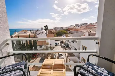 a balcony with chairs and a view of the ocean at Apartment Bay View Andrea mit Meerblick und Pool in Albufeira