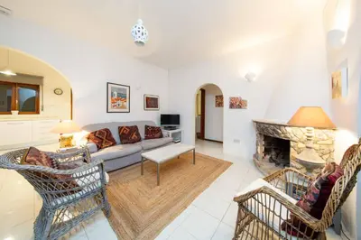 a living room with a couch and a fireplace at Villa Jacaranda Bordeira in Corotelo