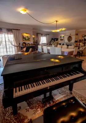 a black piano sitting in a living room with a living at Al Meida Guesthouse in Albufeira